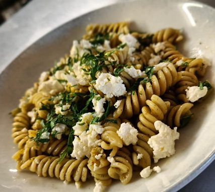 Pâtes en spirale avec fromage émietté et herbes fraîches.